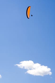 Parachuter flying on clear blue sky with white cloud