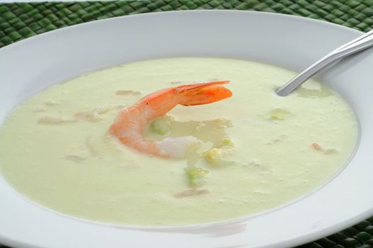 Cold avocado, cucumber and seafood soup in a bowl.