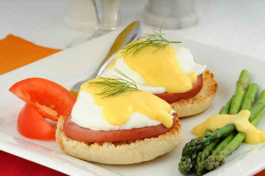 Delicious eggs benedict served with fresh vegetables.