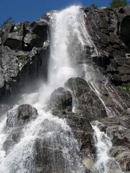 tall nordic waterfall and the blue sky