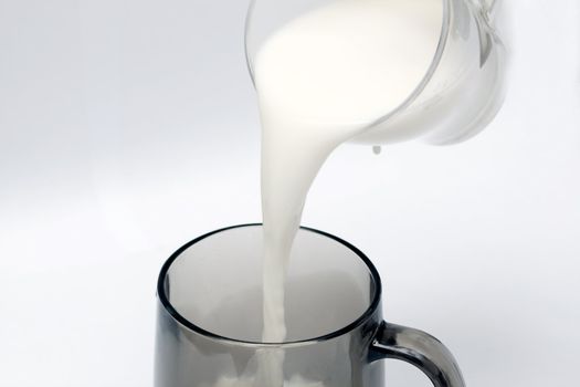 pouring milk to a black glass