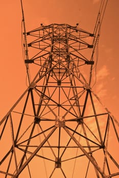 Power transmission pole against sunset skies