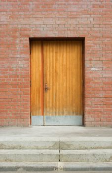 locked old wooden door in a wall of red bricks