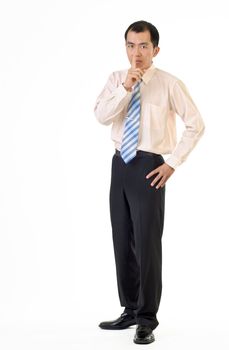 Asian businessman gesture with finger on lips showing silence sign and standing on white background.