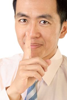 Silence sign with Asian businessman finger near lips on white background.