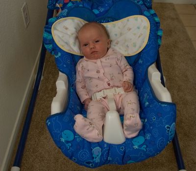 One month old caucausian girl in baby bouncer seat.