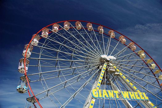 big wheel in cardiff bay in nice summer day with blue sky covered by clouds