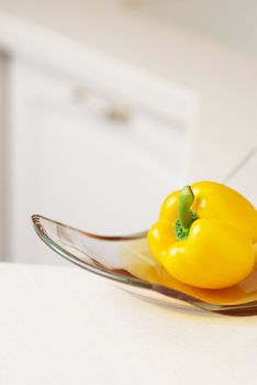 Yellow sweet pepper on white kitchen's table