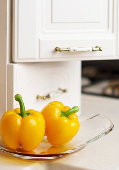 Yellow sweet pepper on white kitchen's table