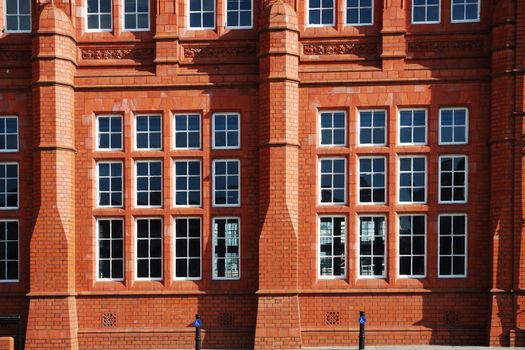 wall of red historical building in cardiff bay with windows