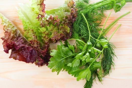 Salad,dill and parsley on wooden board