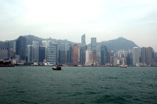 General view of Hongkong, cityscape with modern skyscrapers, harbour and small fisherman's boat.