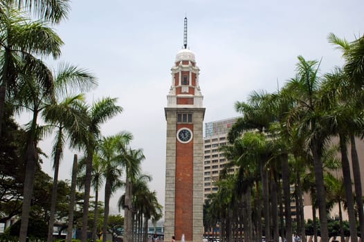 Old clocktower between palm trees in Hongkong, Kowloon.