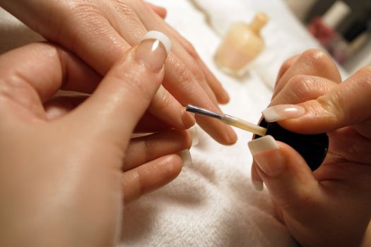 A manicurist applying nail polish during a manicure.
