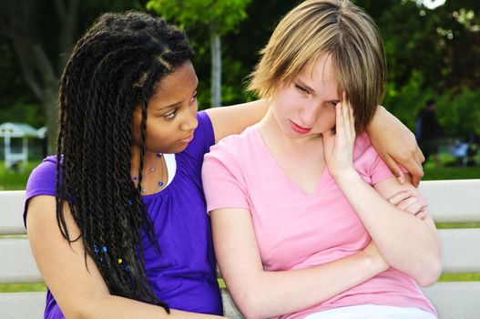 Teenage girl consoling her sad upset friend