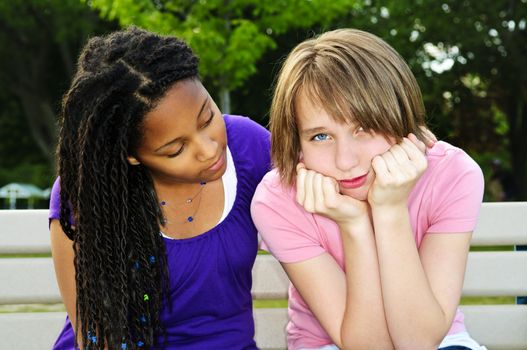 Teenage girl consoling her sad upset friend