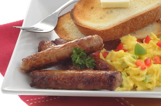 Breakfast sausages served with eggs and toast.