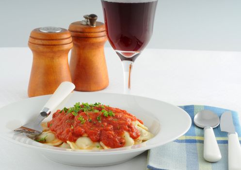 Fresh homemade ravioli with marinara sauce and herbs.