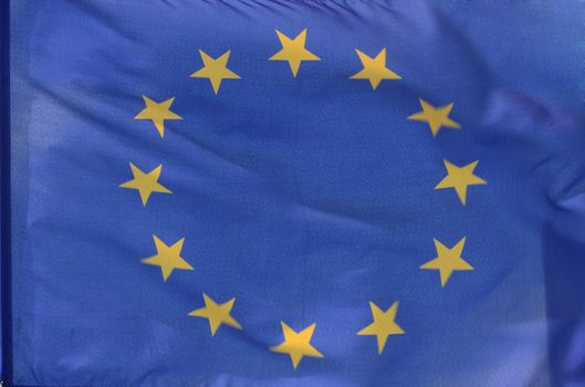 The flag of the european union filling the frame, parts of it blurry because of strong wind