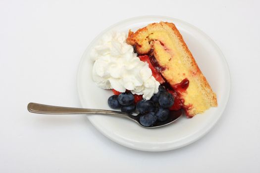 slice of strawberry cake with whipped cream and blueberries isolated on white 