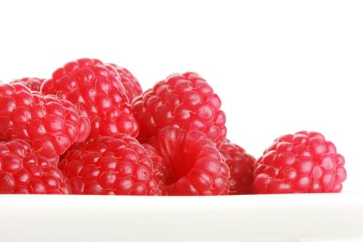 very juicy looking raspberries shot in studio, isolated on white