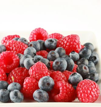 bunch of fresh blueberries and raspberries, isolated on white, great fruit background