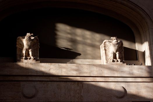 Two stone sculpture of eagle opposite one another 
