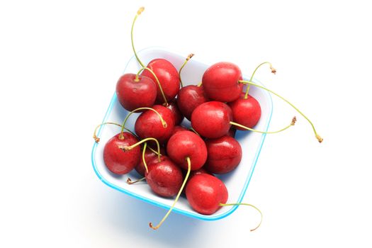 Bowl of fresh red cherries, isolated on white shot in studio