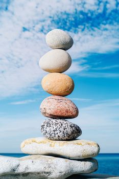 A stack of round pebbles on background the cloudy sky