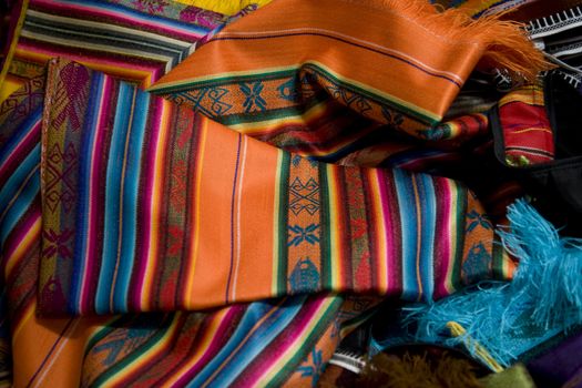 An array of brightly colored Mexican shawls.