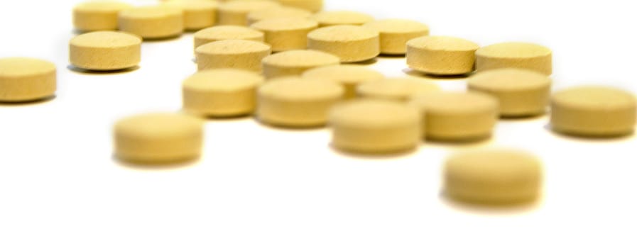 Tablets of beige color on white background. Isolation, shallow DOF. Focus on tablets in the middle