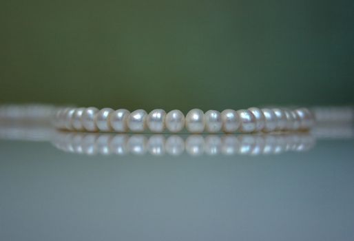 Old pearl beads on a greenish background. Shallow DOF