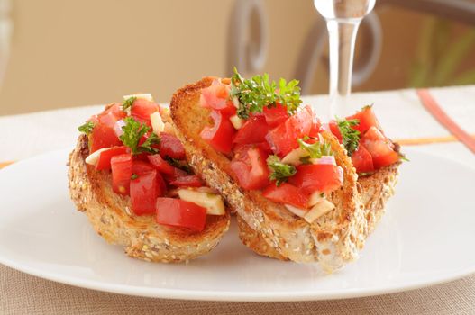Fresh made colorful bruschetta on a white plate.