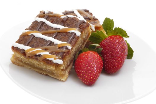 Delicious caramel crunch dessert square and strawberries.