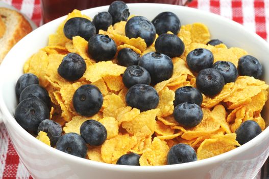 Bowl of ripe blueberries served on corn flakes.