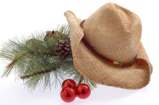Pine bough and well worn cowboy hat on white background.