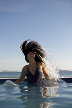 Woman relaxing on a swimming pool with a sea view in Rio de Janeiro, Brazil