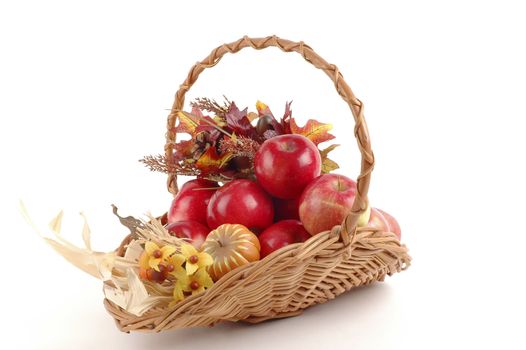Basket of fresh apples mixed with fall foliage.
