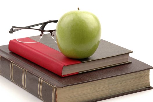 Hardcover school books and apple still life.