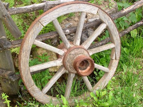 Wooden Horse Carriage Wheel Leaned on a Fence