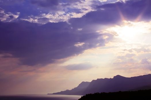 The sun came out because of the clouds. Evening on the Black Sea. Soon the sun over the mountains and hided occur overnight.