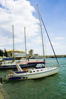 Yachts at the berth. Summer. Sunny Day. At the second yacht sailors are preparing for departure.