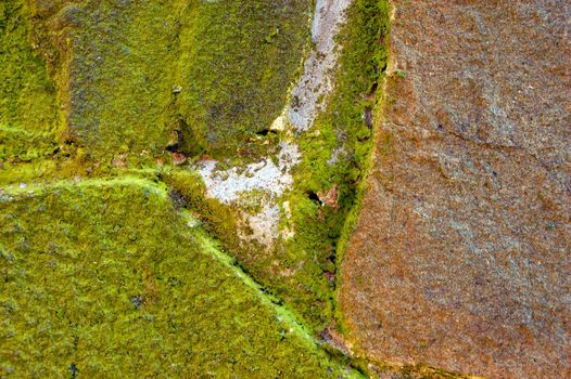 colored (prevaling green and brown) rough stone surface with lichen