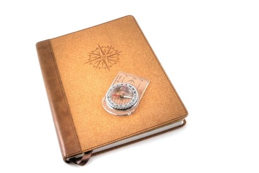 A brown travel journal imprinted with a compass rose, isolated on white.