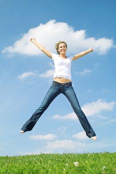 Beautiful lady in jeans jumping over blue sky 