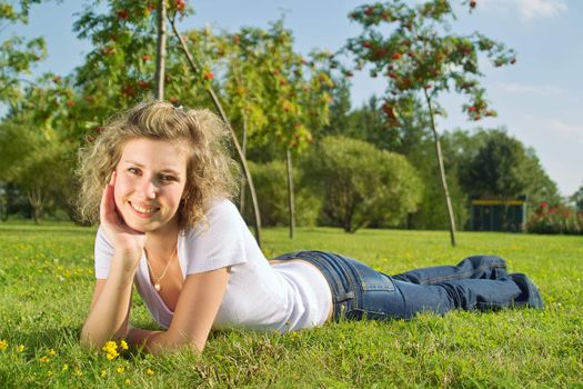 A beautiful lady sitting on the grass in sunny day