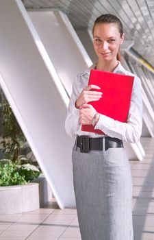 Portrait of beautiful young business woman with red folder