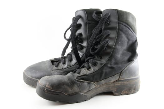 A pair of black, worn combat boots isolated on white.