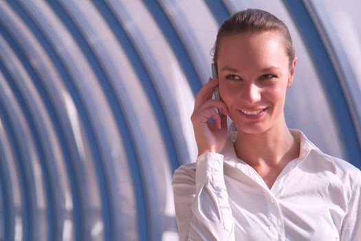 Beautiful young business woman speaks by phone