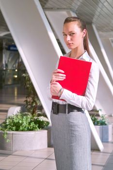 Portrait of beautiful young business woman with red folder